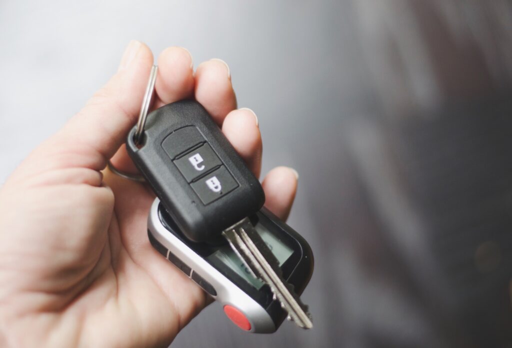 Woman hand car keys handful grey background